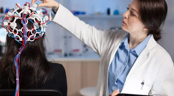 Lekarka zakłada pacjentce czepiec EEG, badając mózg. To przykład badań w neurologii, co to jest i jak działa.